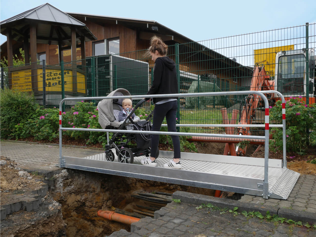 3,3m lange schake grabenbruecke wird von frau mit kinderwagen genutzt