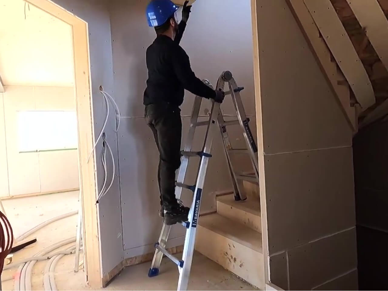 handwerker nutzt teleskopleiter als stehleiter auf einer treppe mit mehreren stufen
