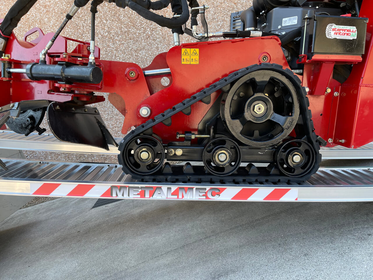 seitliche ansicht einer m065 auffahrrampe beim verladen einer maschine mit gummiketten