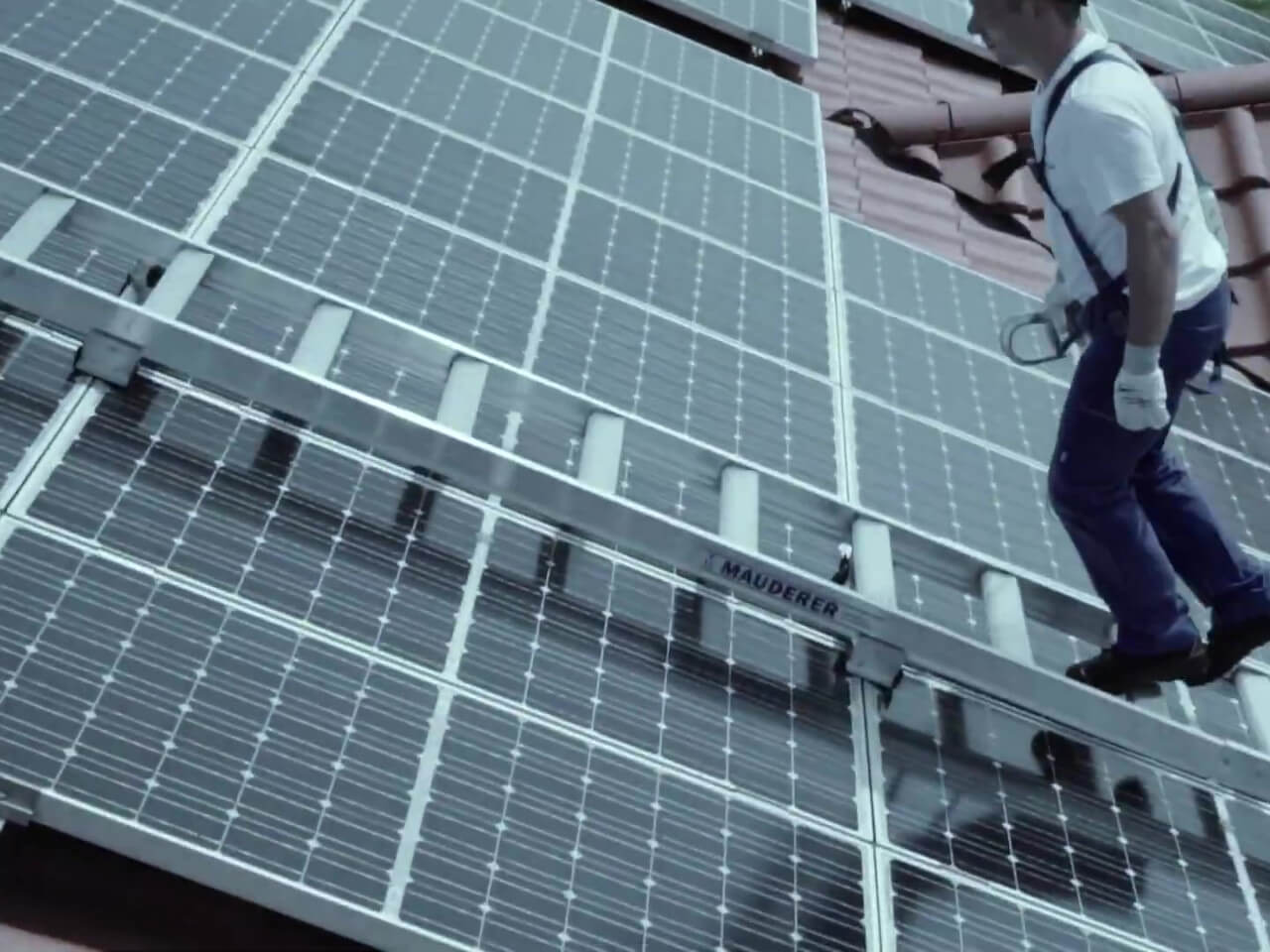 handwerker nutzt mauderer leiter zur installation vom solardach