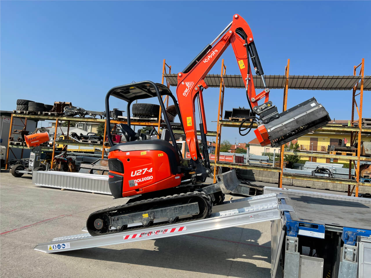 bagger faehrt ueber m140 auffahrrampen auf transportfahrzeug