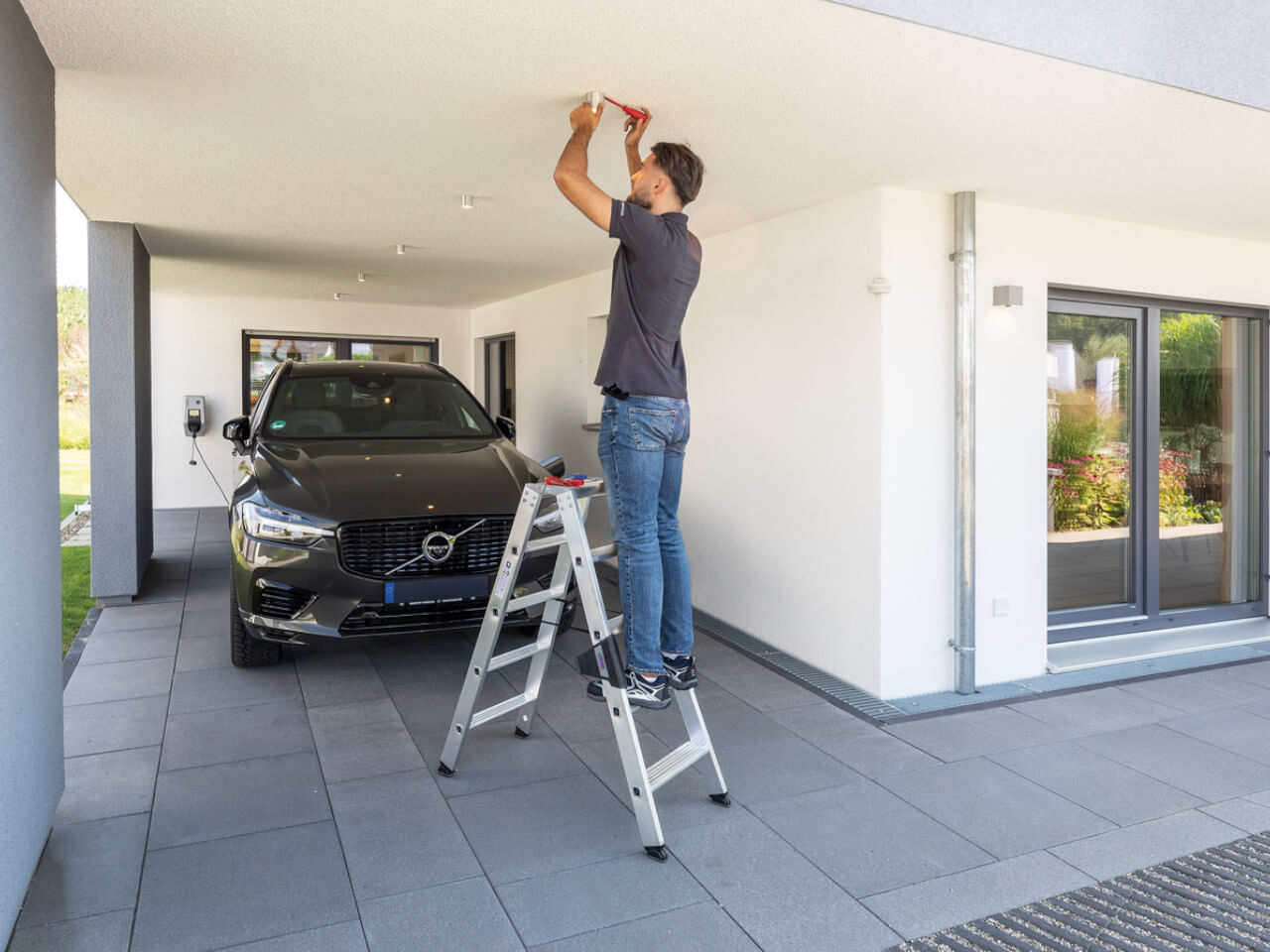 handwerker steht auf einer stufen-stehleiter von munk