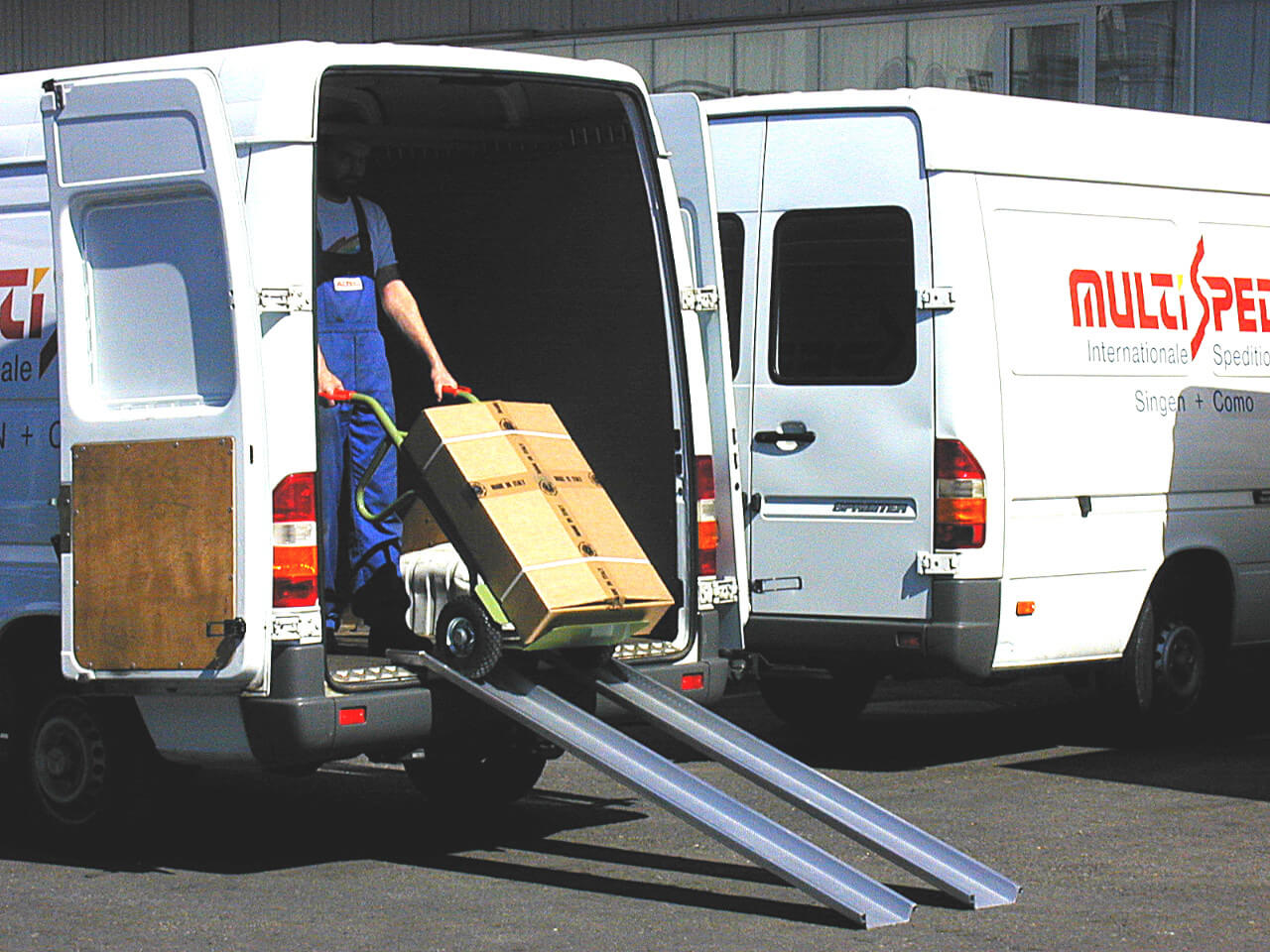 mann mit transportkarre nutzt auffahrrampen am transporter