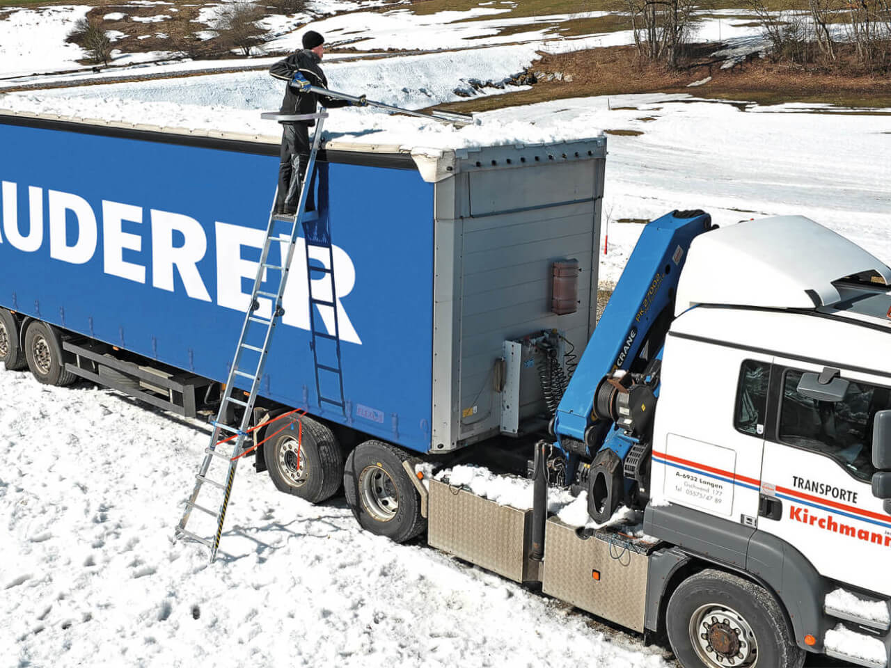 person auf enteisungsleiter befreit lkw dach von schnee und eis