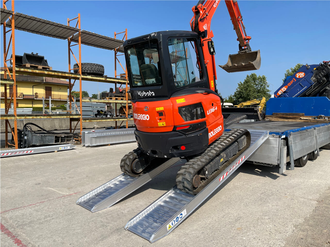 bagger wird auf transportfahrzeug mithilfe von m160 auffahrrampen verladen