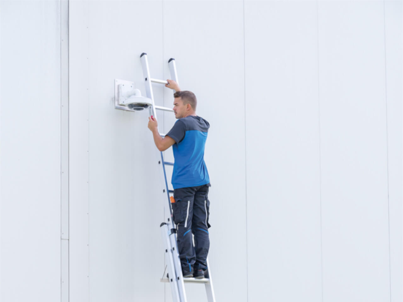 handwerker steht auf sprossen-schiebeleiter von munk steigtechnik