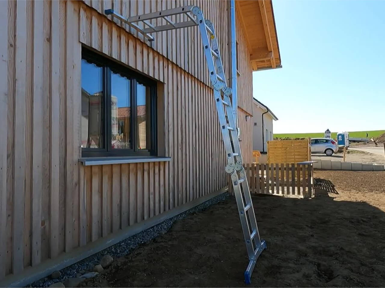 alu leiter mit gelenk liegt an hauswand an