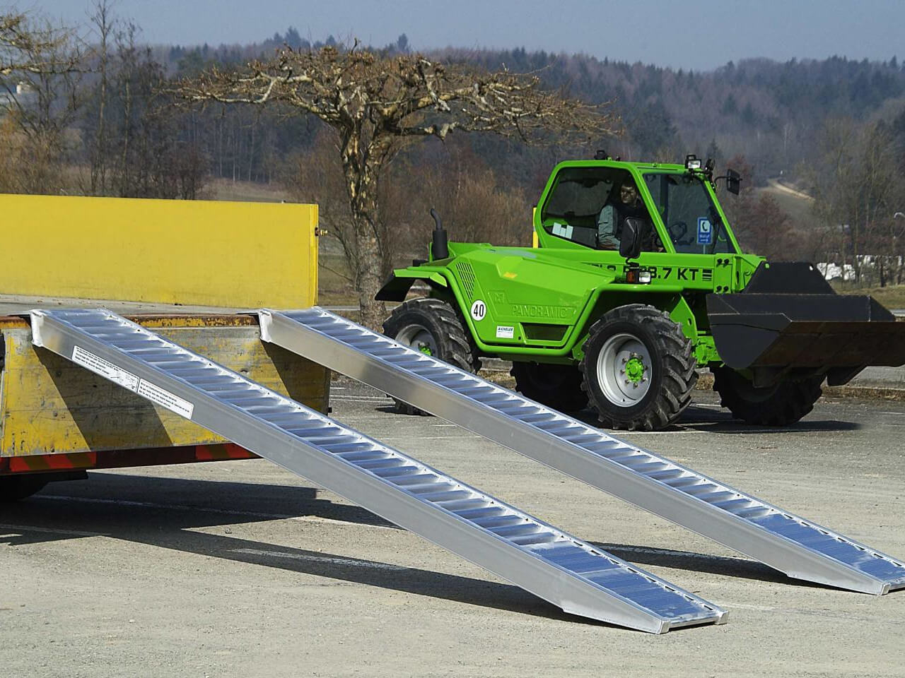 radlader wird mithilfe von avs auffahrrampen verladen