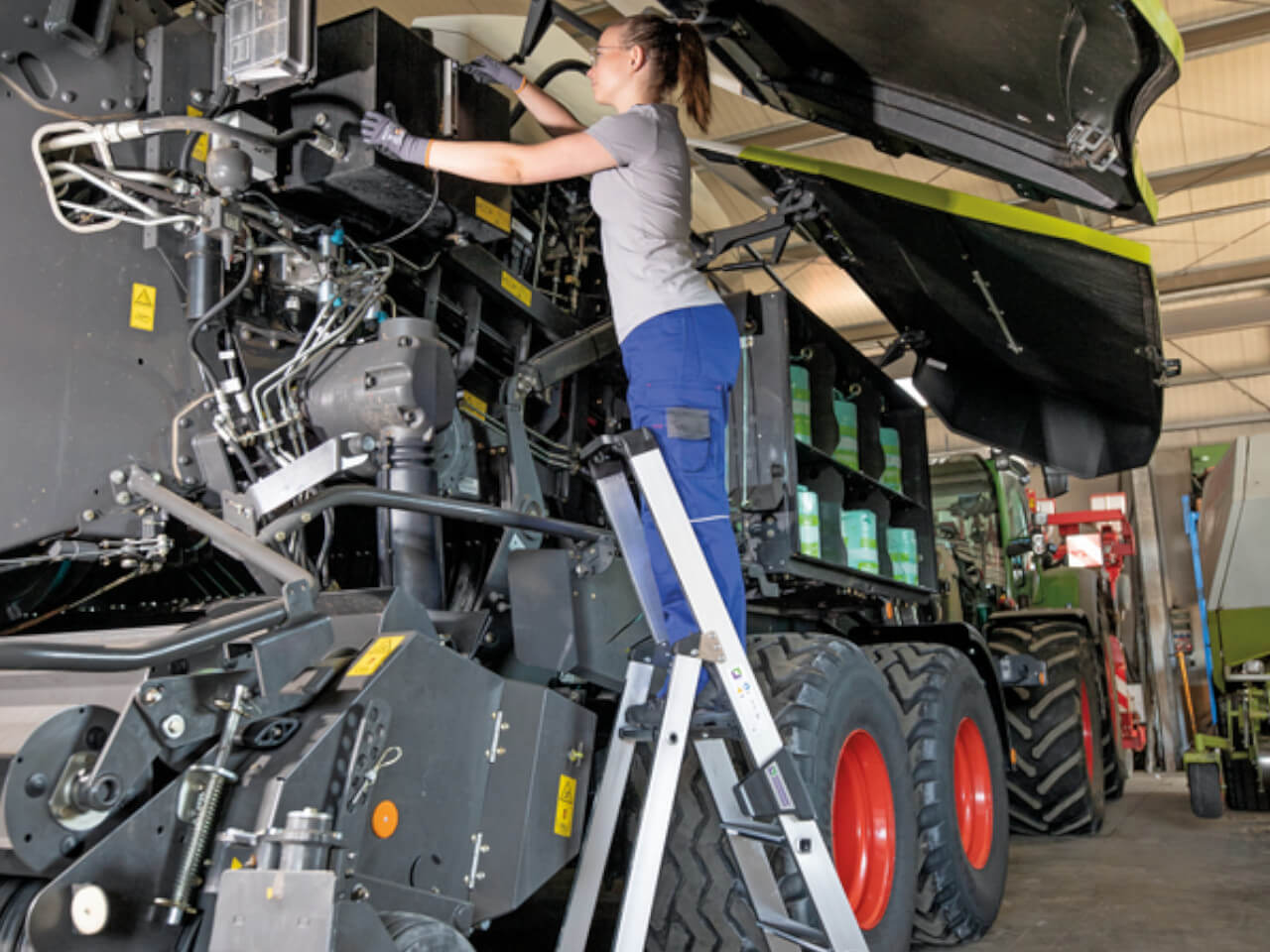 mechanikerin baut eine maschine auf einer munk stufen-stehleiter 42104