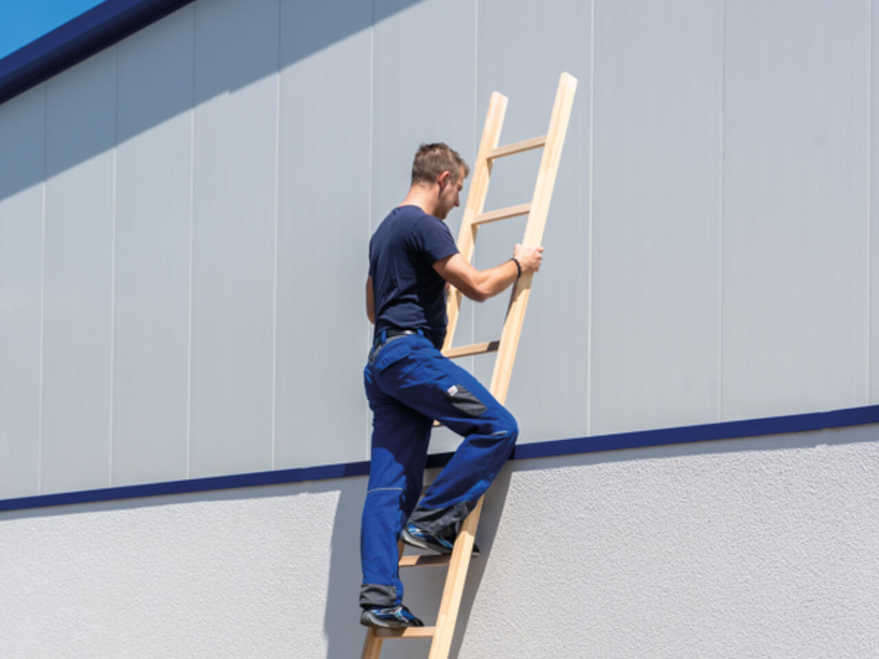 handwerker mann auf einer munk sprossen anlegeleiter aus holz