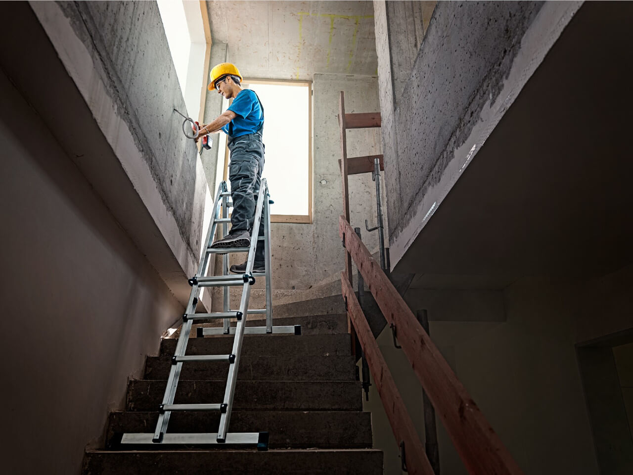 handwerker mit sicheren stand auf einer werner gelenkleiter