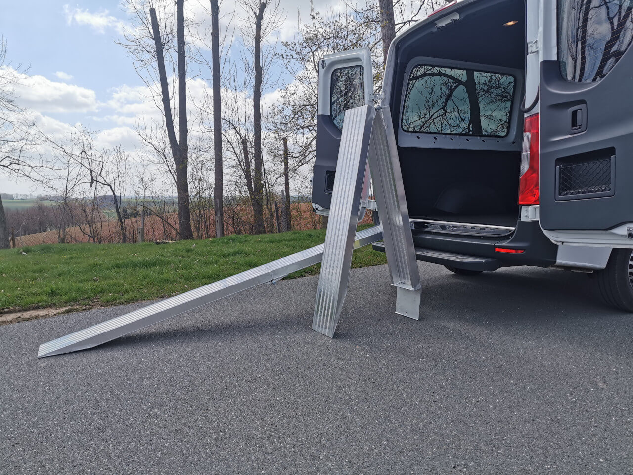 klappbare alu auffahrrampe steht neben einen mercedes sprinter